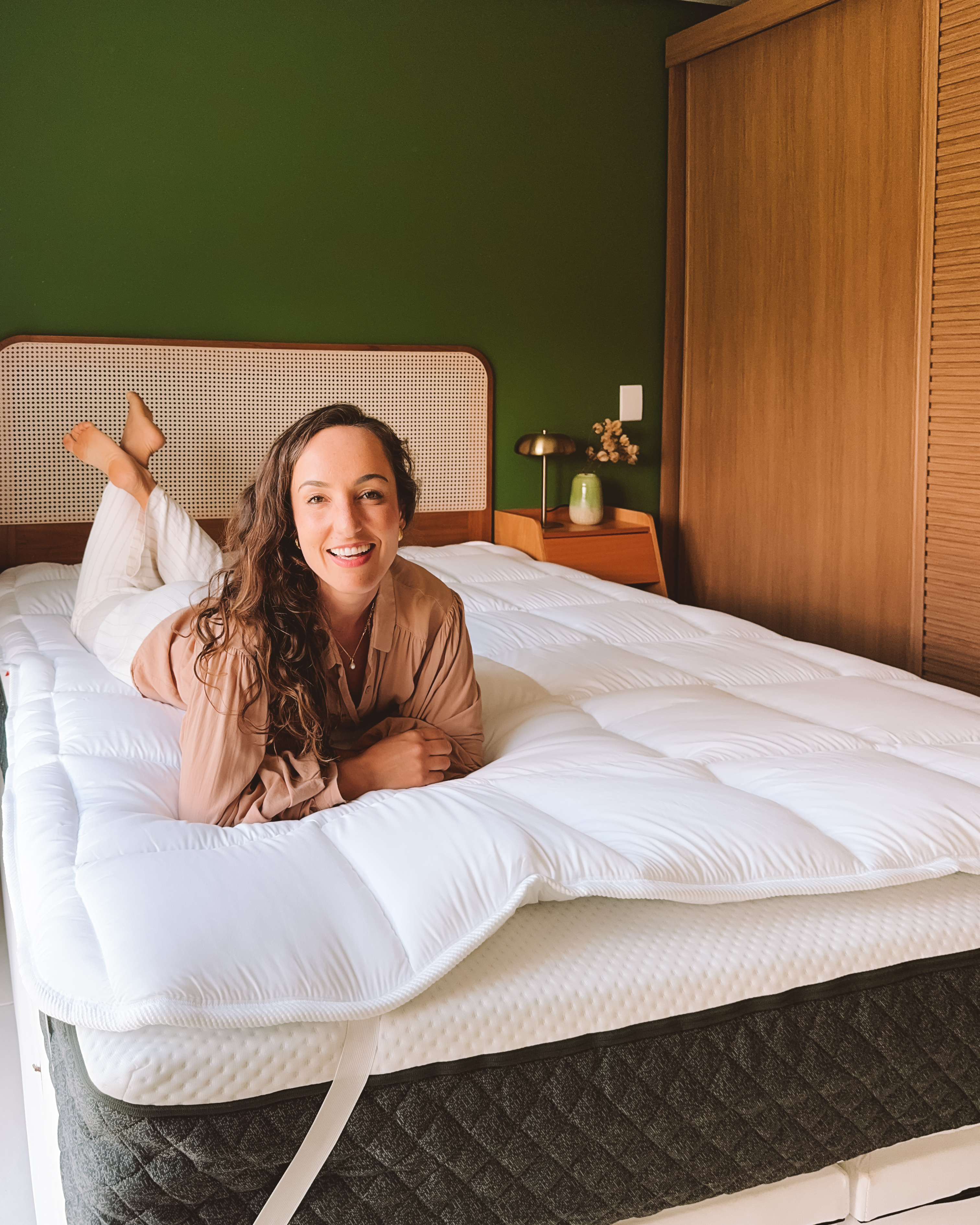 Quarto iluminado pelo sol com foco na cama branca e aconchegante